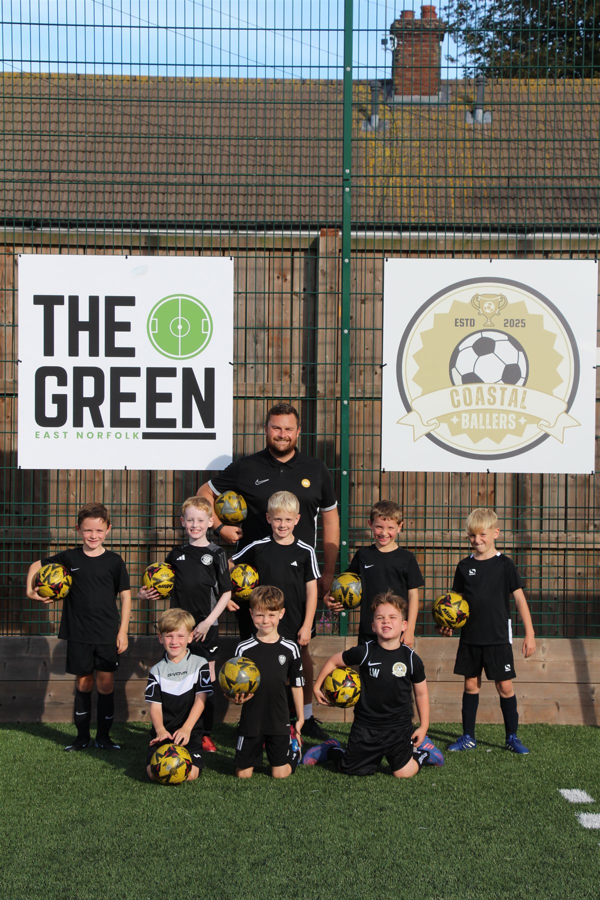 Young Coastal Ballers football players with their coach at The Green